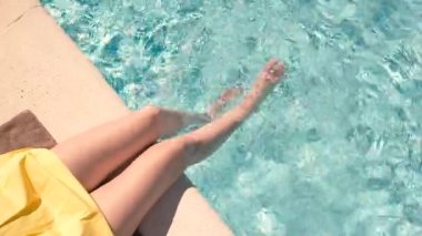 Yüzme havuzunda kadın bacakları.