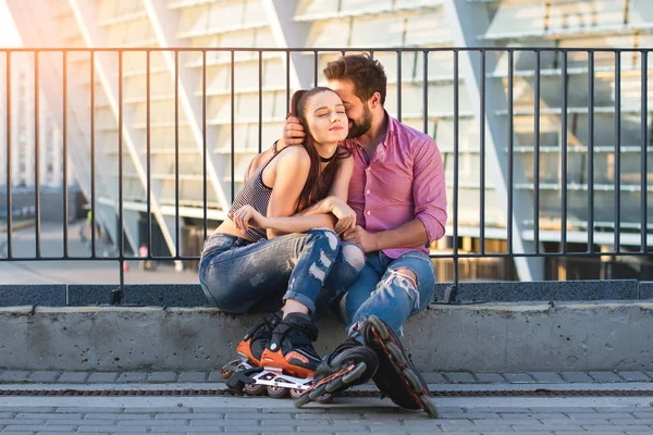 Pár inline bruslařů sedí. — Stock fotografie