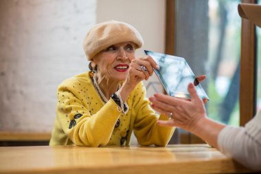 Yaşlı kadın bir tablet holding.