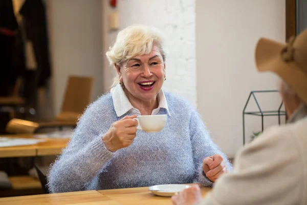 Smiling senior woman holds cup. — Stock Photo, Image