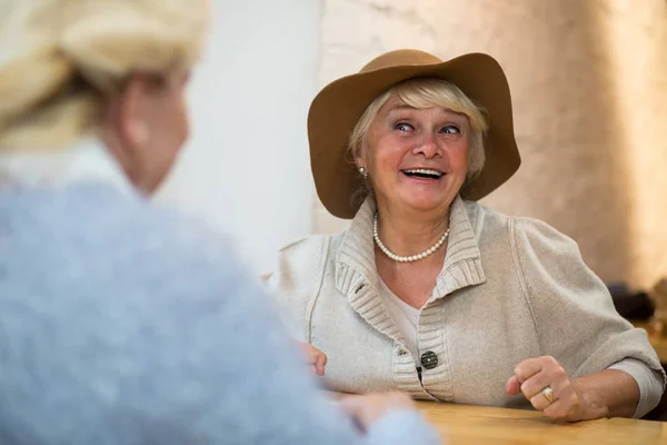 Smiling senior woman at table. — Stock Photo, Image