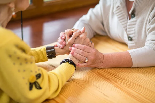 Two senior women holding hands. — Stock Photo, Image