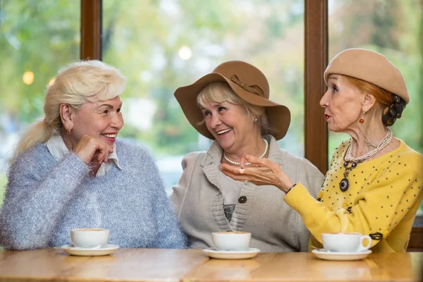 Улыбающиеся пожилые женщины за столом . — стоковое фото
