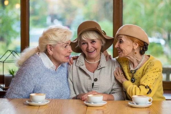 Senior women at table smiling. — Stock Photo, Image