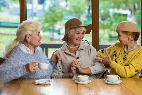 Three elderly ladies drinking coffee. — Stock Photo, Image