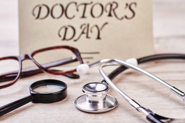 Büyüteç, stetoskop ve tebrik kartı.