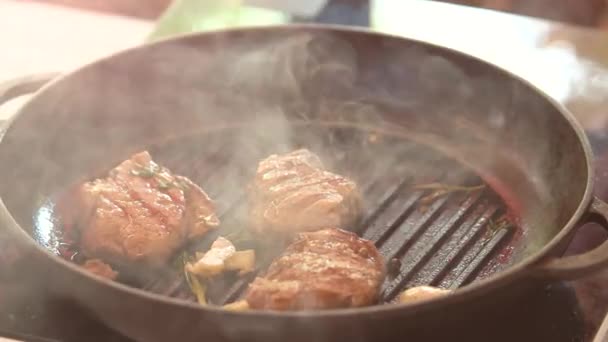 Kleště překlápění steaky v pánvi. — Stock video