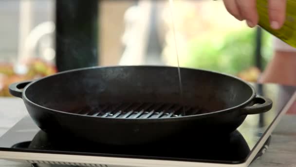 Рука наливає олію в сковороду . — стокове відео