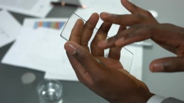Erkek elinde şeffaf telefon.