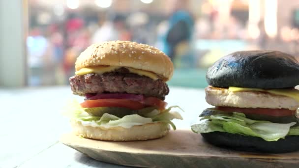 Drie hamburgers en houten bord. — Stockvideo