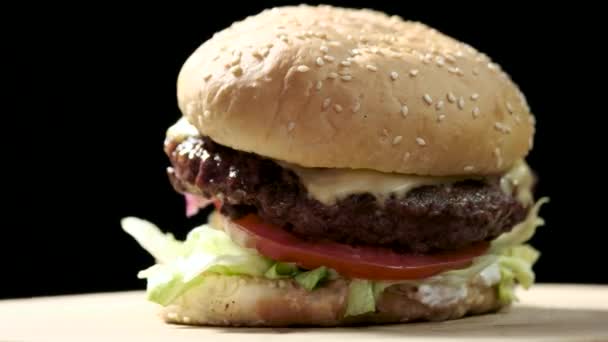 Hamburger close-up na černém pozadí.