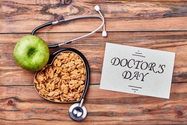 Stetoskop, kart, elma ve ceviz.