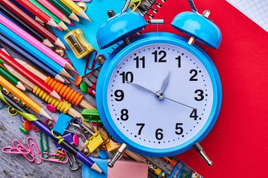 Boya kalemi, çalar saat ve defter.