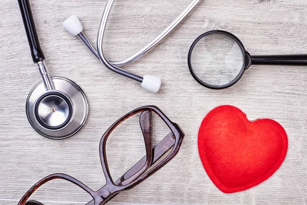 Kırmızı kalp, Büyüteç ve stetoskop. — Stok fotoğraf
