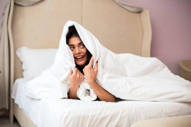 Kadın battaniyenin altında saklanıyor.