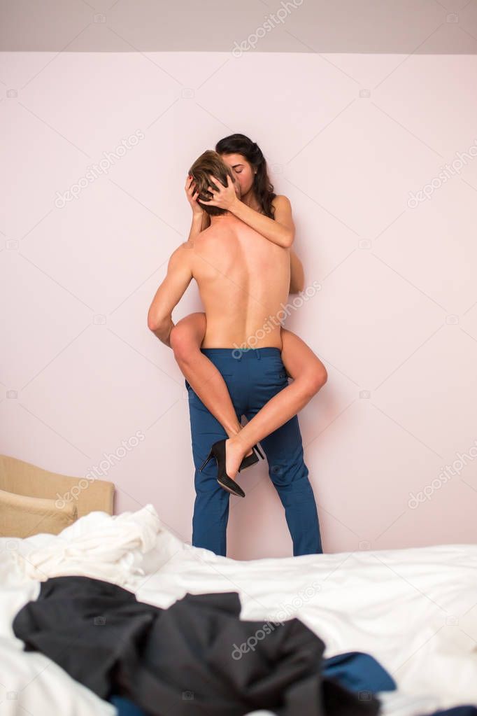 Shirtless man is holding woman.