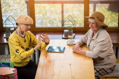 Kafe masasında yaşlı kadınlar.