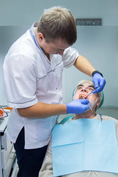 Dentystyczny lekarz z podeszłym wieku pacjenta. — Zdjęcie stockowe