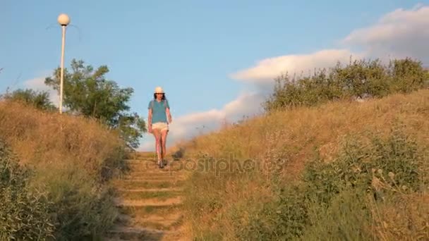 女の子は階段を下りて行きます。野生の夏の自然. — ストック動画
