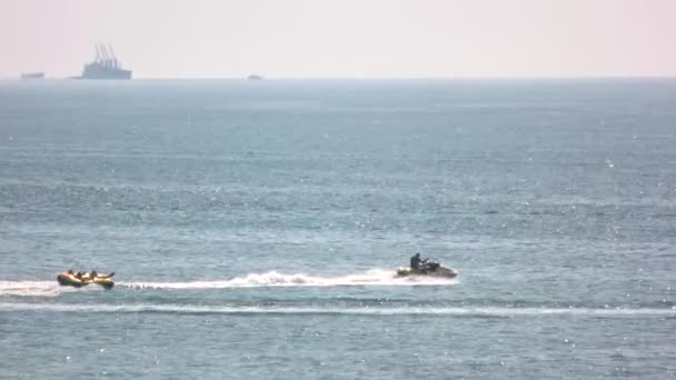 La gente cavalca su un cuscino gonfiabile sul mare . — Video Stock