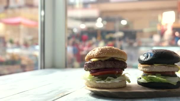 Tre hamburger su tavola di legno . — Video Stock