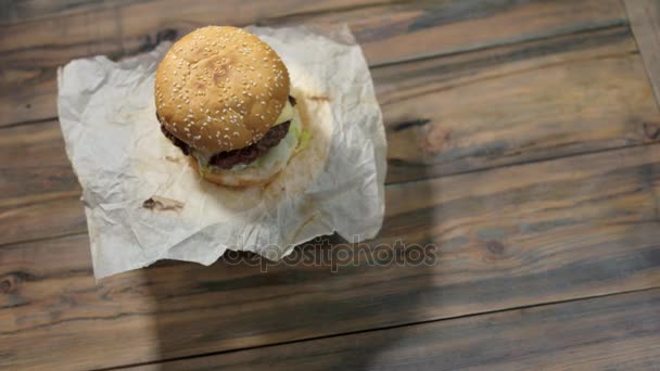 Cheeseburger auf Holz-Hintergrund. — Stockvideo