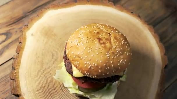 Burger on wooden board rotating. — Stock Video