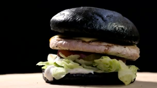 Hamburger met zwarte broodje. — Stockvideo