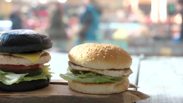 Houten bord en drie hamburgers. — Stockvideo