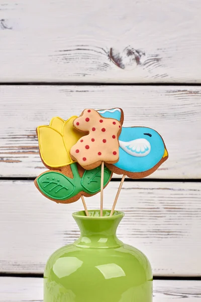 Vase und Kekse auf Stöcken. — Stockfoto