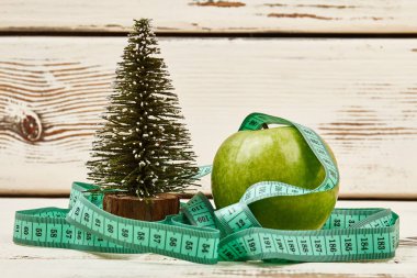 Çam ağacı, elma ve ölçüm bandı.