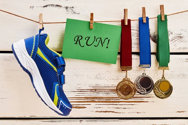 Zapatilla de deporte y premios en tendedero . — Foto de Stock