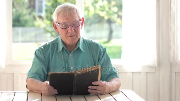 Senior die een boek leest. — Stockvideo