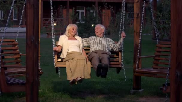 Couple assis sur la balançoire porche . — Video