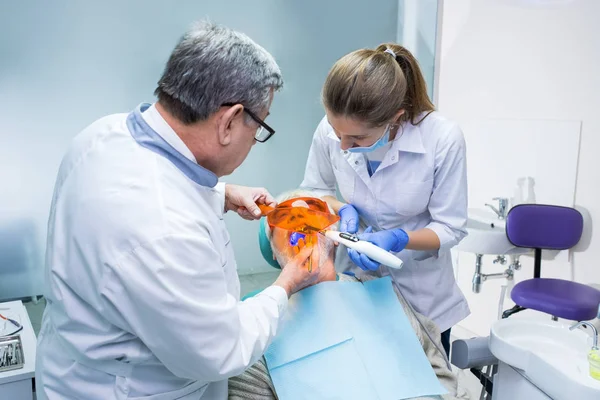 Лікар стоматолог використовує ультрафіолетове світло . — стокове фото