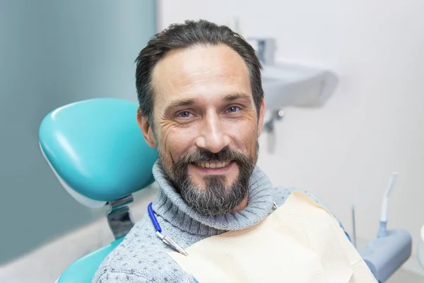 Smiling man in dental chair.