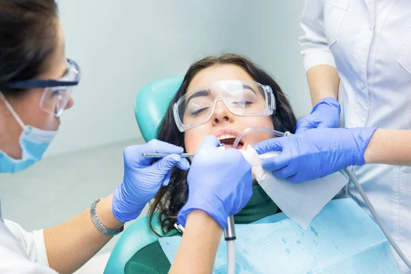 दंत चिकित्सक रोगी के साथ काम कर रहे हैं . — स्टॉक फ़ोटो, इमेज