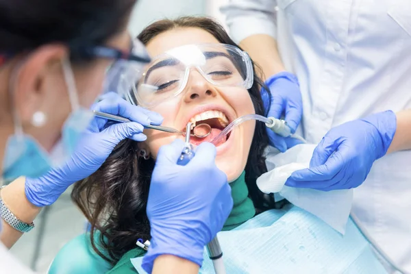 Två tandläkare upptagen med patient. — Stockfoto
