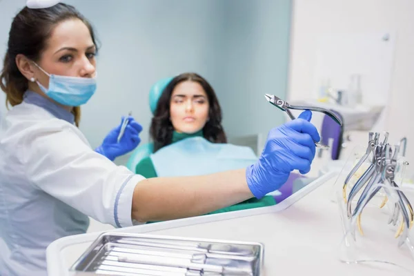 Dentista feminina está segurando alicate . — Fotografia de Stock