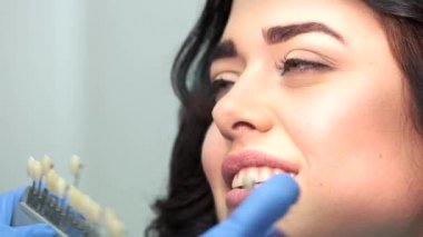 Diş renk tablosu tutan el.