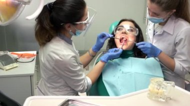 Diş hekimleri ve hasta, su şırınga.