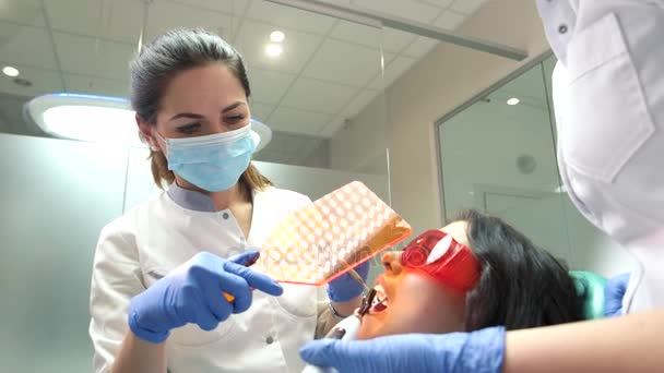 Dentist holding uv light shield. — Stock Video