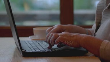 Yaşlı kadınların elleri ve laptopları.