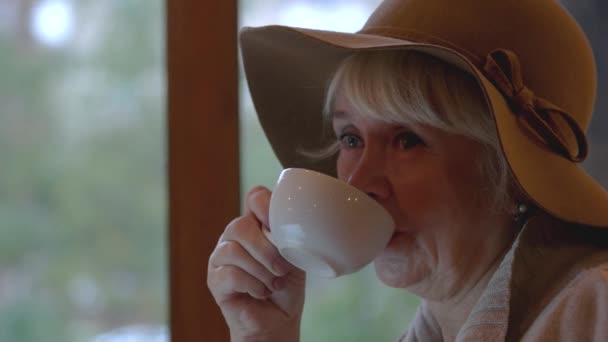 Senior mulher segurando copo branco . — Vídeo de Stock