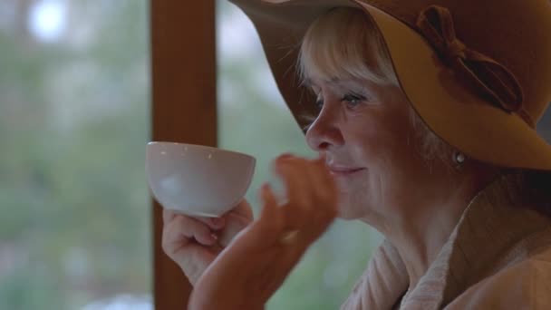 Старша леді п'є з чашки . — стокове відео