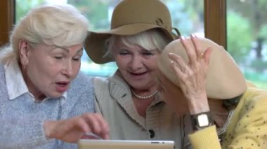 Tablet gülümseyen kıdemli kadınlar.