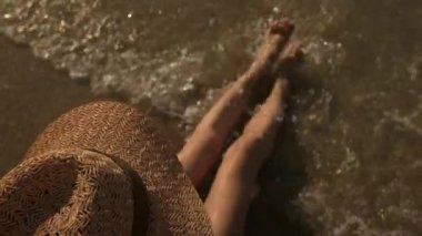 Deniz kıyısı üzerinde şapkalı Bayan.