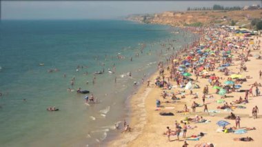 Deniz kenarında birçok kişi.