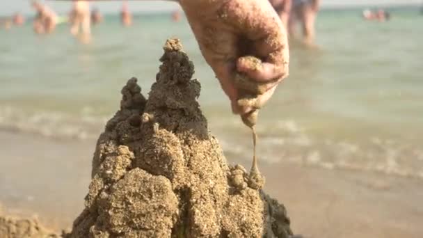 Main d'enfant, tour de sable goutte à goutte . — Video