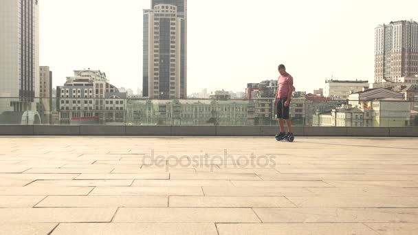 Man op hoverboard, stad achtergrond. — Stockvideo